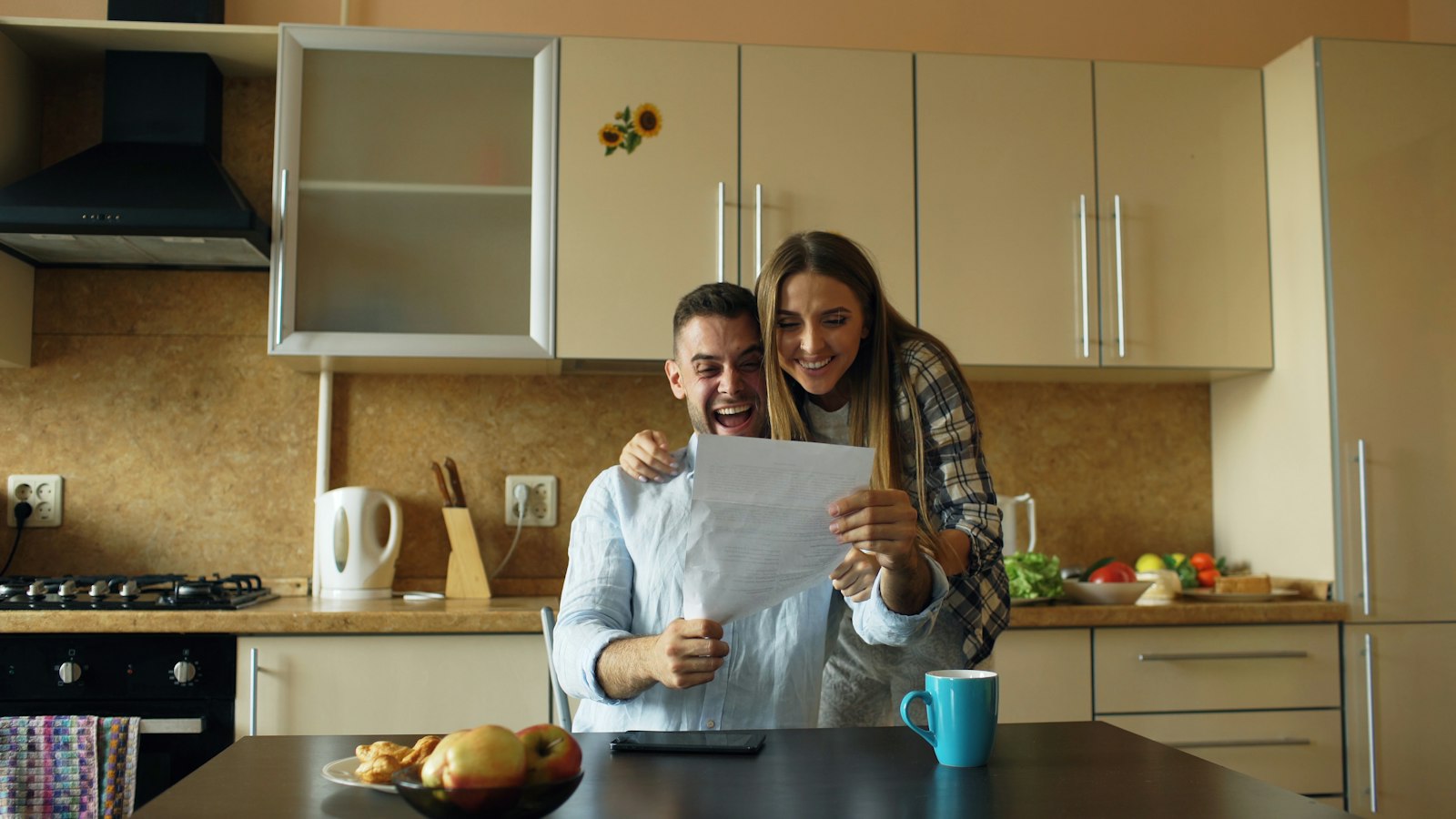 A couple reading good news together at their kitchen table