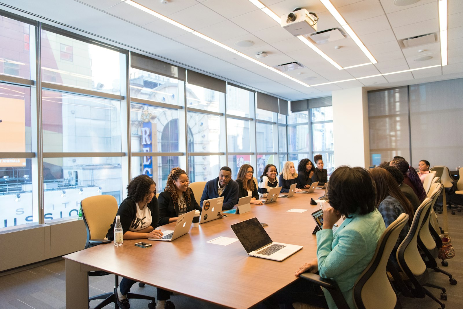 A team working together at a long conference table with laptops